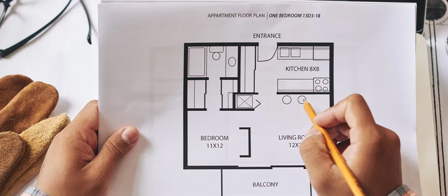 person with pencil making changes to floorplan measurements